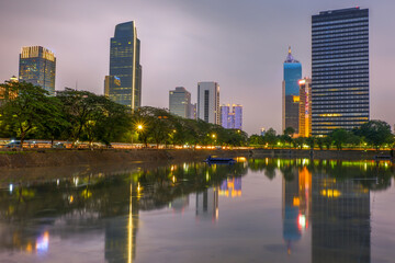 Fototapeta na wymiar Jakarta capital city skyline, office buildings and business centers reflected on water in the dusk