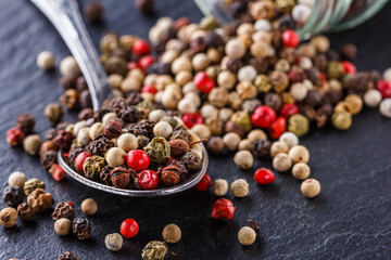 mix of peppercorns on a dark stone background