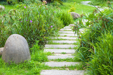 Obraz premium The stone walkway winding its way through a tranquil summer garden