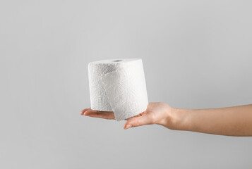 Hand holding toilet paper roll