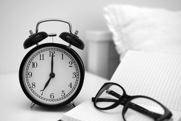 Alarm clock on table with notebooks and glasses. Wake up concept. An image of a alarm clock showing...