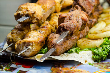 Grilling marinated shashlik on a grill. Shish kebab in the open air on the grill. Cooking meat on the street.