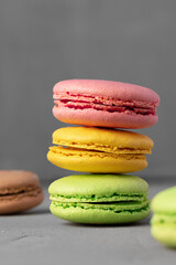 Colorful macaroon cookies on grey surface close up