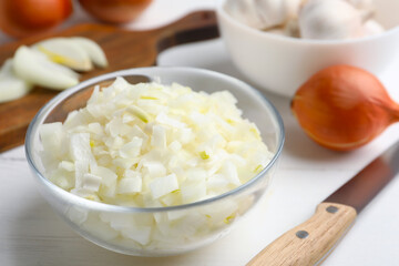 Chopped onion in bowl on white wooden table