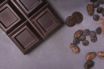 Chocolate bar and drops on the grey table