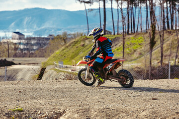 Motocross driver in action, ready to go and looking up for the trail