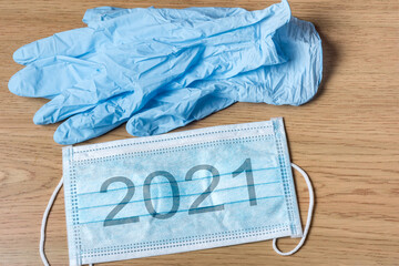 Protective medical mask with the inscription 2021 and latex gloves.