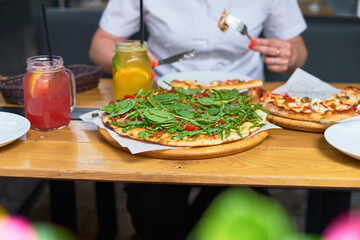 Fresh whole pizza and lemonade on a terrace table in Italy