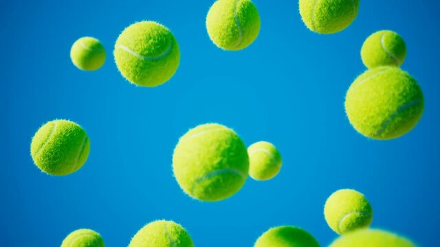 Loopable footage of falling tennis balls. Slow-motion. Blue background. 4K HD