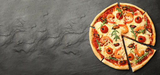 Top view of hot delicious pizza on dark table, space for text. Banner design