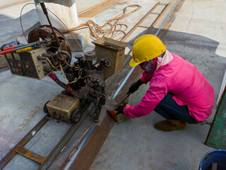 The welder is welding add joint a steel plate with process Submerged Arc Welding(SAW) at industrial...