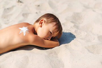 Kid on the beach with sunscreen on his back. Travel. Summer vacations.