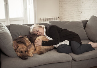 Depressed lonely senior woman in isolation at home with pet dog as only companion
