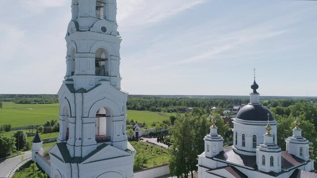 Aerial photography of the Orthodox Church, the camera rises up next to the white chapel and the Church, shooting on a Sunny summer day