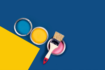 Blue background with paint jars. Self-repair. Classic blue and yellow background with three colored cans of acrylic paint and one brush.