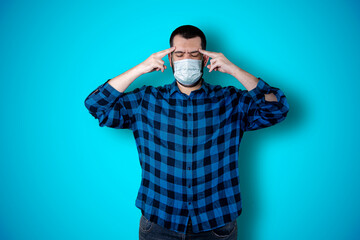 Caucasian handsome man isolated on blue background thinking an idea while looking up using mask. Coronavirus concept