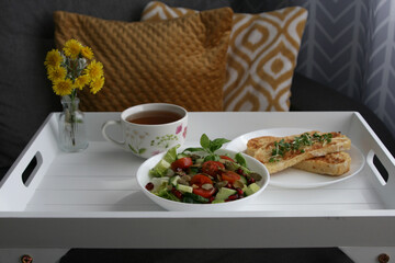 healthy breakfast on the tray. Salad, french toasts and tea.