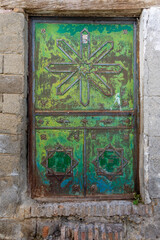 Damaged and rusty arabic style metallic green exterior door