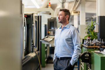Mature businessman standing in a factory