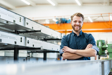 Portrait of a smiling young man in a factory