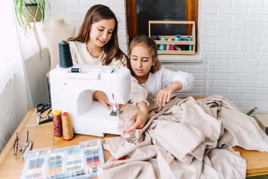 Two girls sewing at home