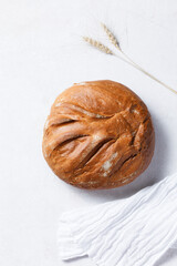 Homemade crusty loave of wheat bread on white background