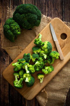 Place mat, cutting board, kitchen knife and fresh broccoli