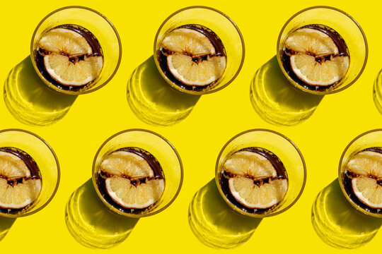 Pattern of rows of cola glasses with lemon slices