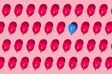 Studio shot of rows of red water balloons with single blue one