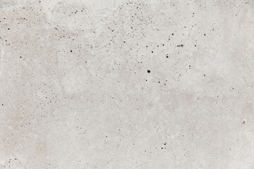 Gray concrete wall with thin cracks and holes. Industrial texture for text and pictures.