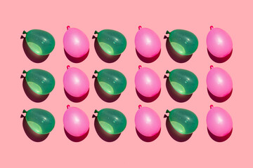 Studio shot of rows of pink and green water balloons