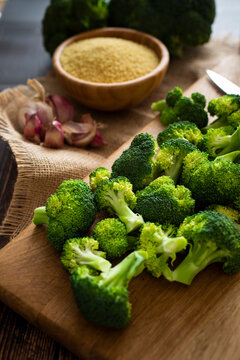 Cutting board, garlic, bowl of couscous, and fresh broccoli