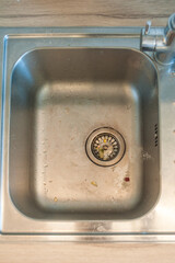 Clogged kitchen sink. Dirty metal sink with leftover food. Close-up