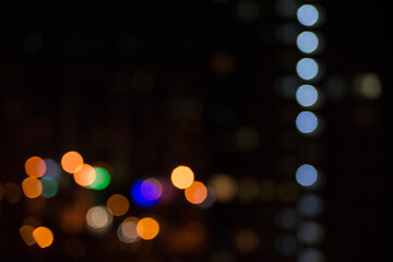 abstract unfocused picture of night city light colorful bokeh from lamps and lanterns, multi-colored spots on a dark background