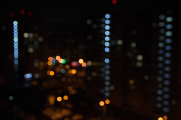 abstract unfocused picture of night city light colorful bokeh from lamps and lanterns, multi-colored spots on a dark background