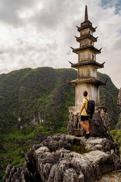 Vietnam, Ninh Binh Province, Ninh Binh, Male hiker standing beside Mua Caves tower