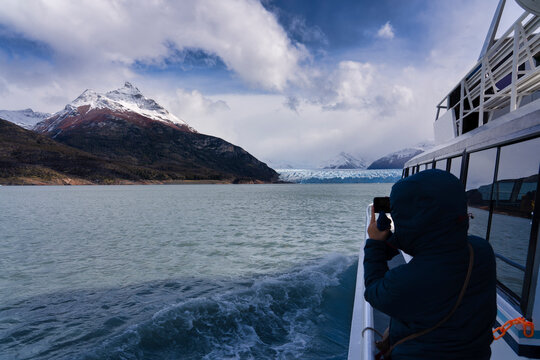 Tourist taking picture of Perito Moreno glacier from boat, El Calafate, Los Glaciares National Park, Patagonia, Argentina