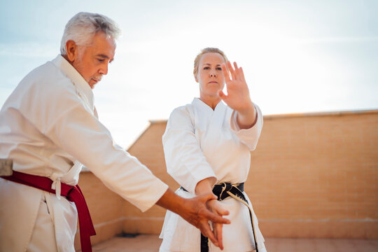 Woman with teacher during karate training on terrace