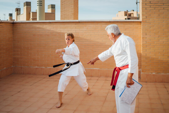Woman with teacher during karate training on terrace