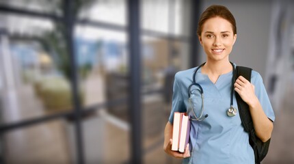 Attractive young female doctor with blurred hospital interior on background