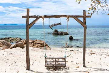 Wooden swing on the beach at Koh Munnork island, Thailand.