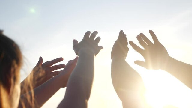 happy family people group pull hands to the sun teamwork. silhouette people party dancing recreation holiday. people at a music concert pull their hands up. religion lifestyle concept sunlight