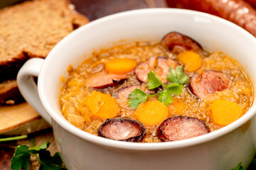 sauerkraut soup in a bowl on a wooden table