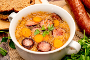 sauerkraut soup in a bowl on a wooden table