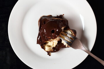 Profiterole with chocolate ganache frosting.  Choux pastry ball with custard filling and chocolate sauce icing. Directly Above.