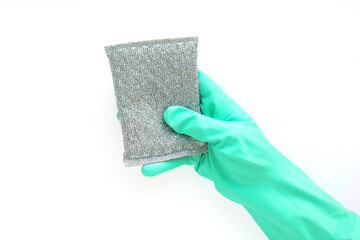 .hand in a blue rubber glove with a silver metallic sponge for washing on a white background....