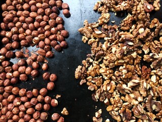 Roasted hazelnuts and walnuts on a baking sheet