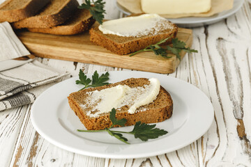 Buttered slice of rye bread on wooden table