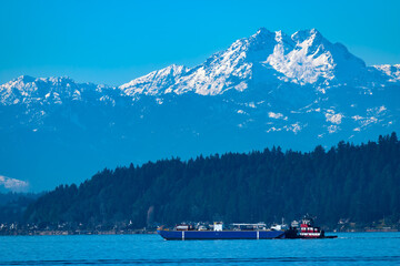 Snow capped Olympic Mountains with foreground barge and tugboat
