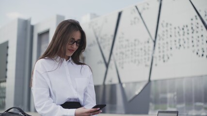 Smiling attractive business woman using smartphone